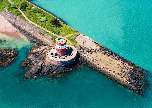 jersey coast with vibrant blue sea and green landscape and rocks and pier